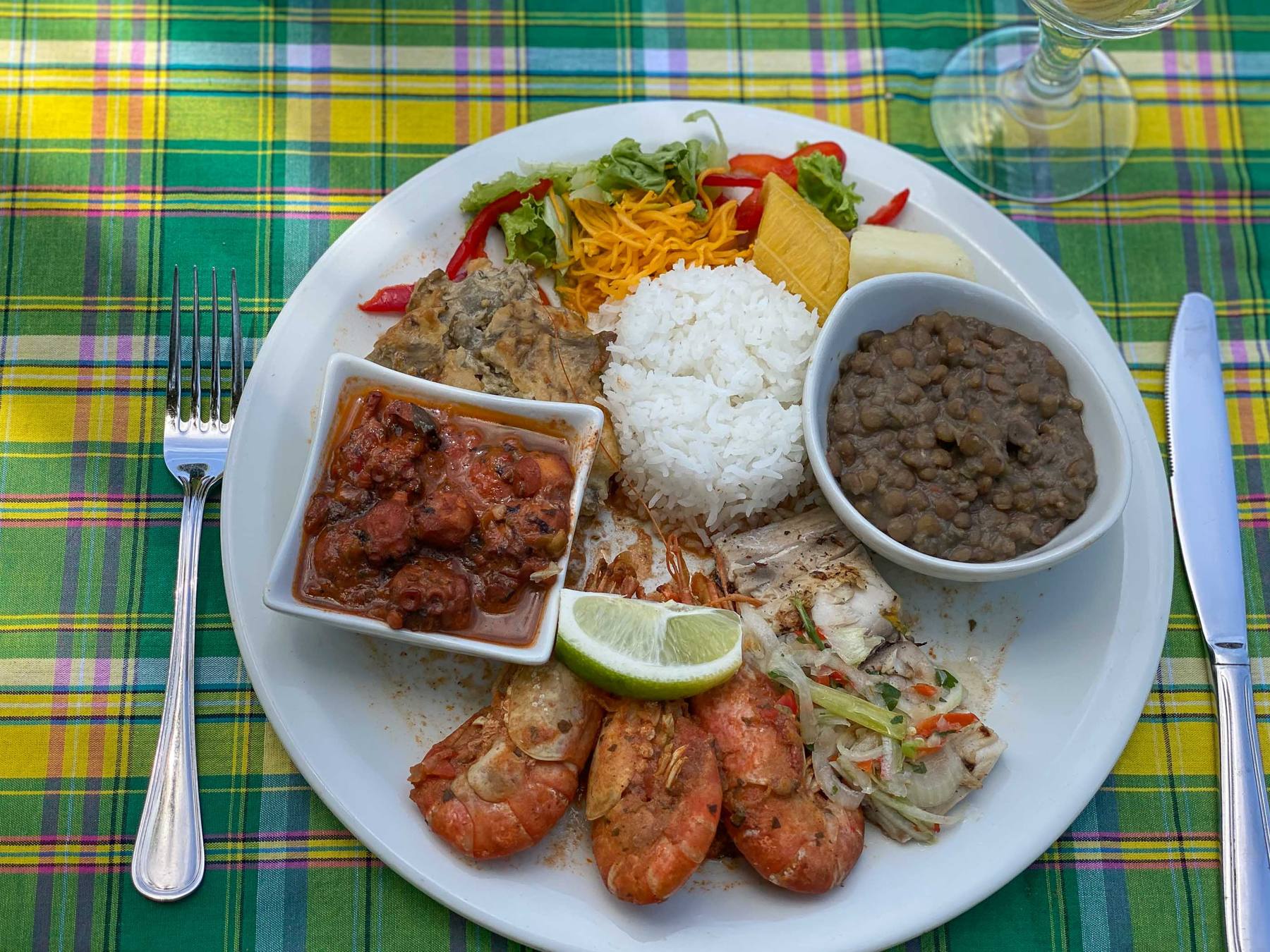 Assiette d'écrevisses avec riz et légumes, sur une nappe madras