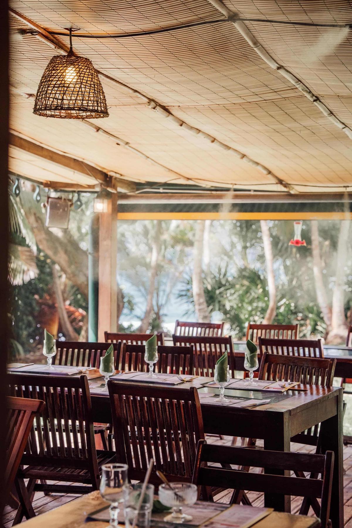Le grand carbet, tables et chaises dressées pour un repas de groupe